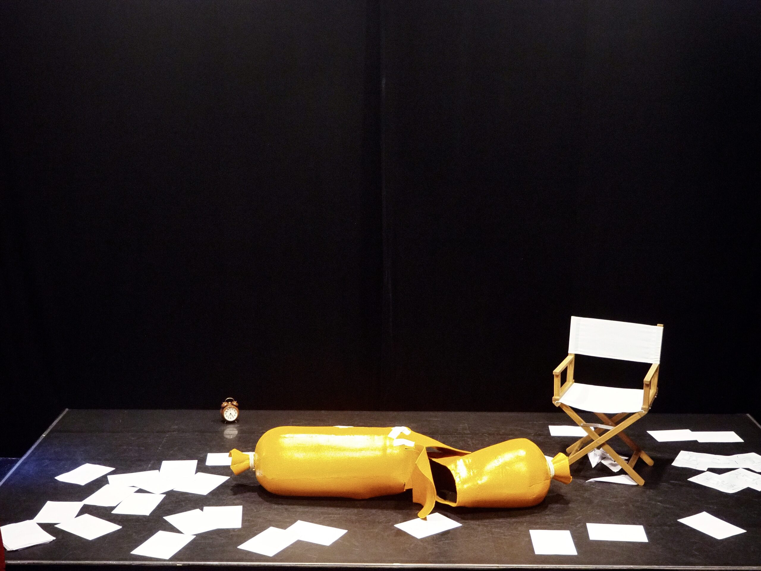 Un costume de saucisse jaune éventrée sur une scène de théâtre